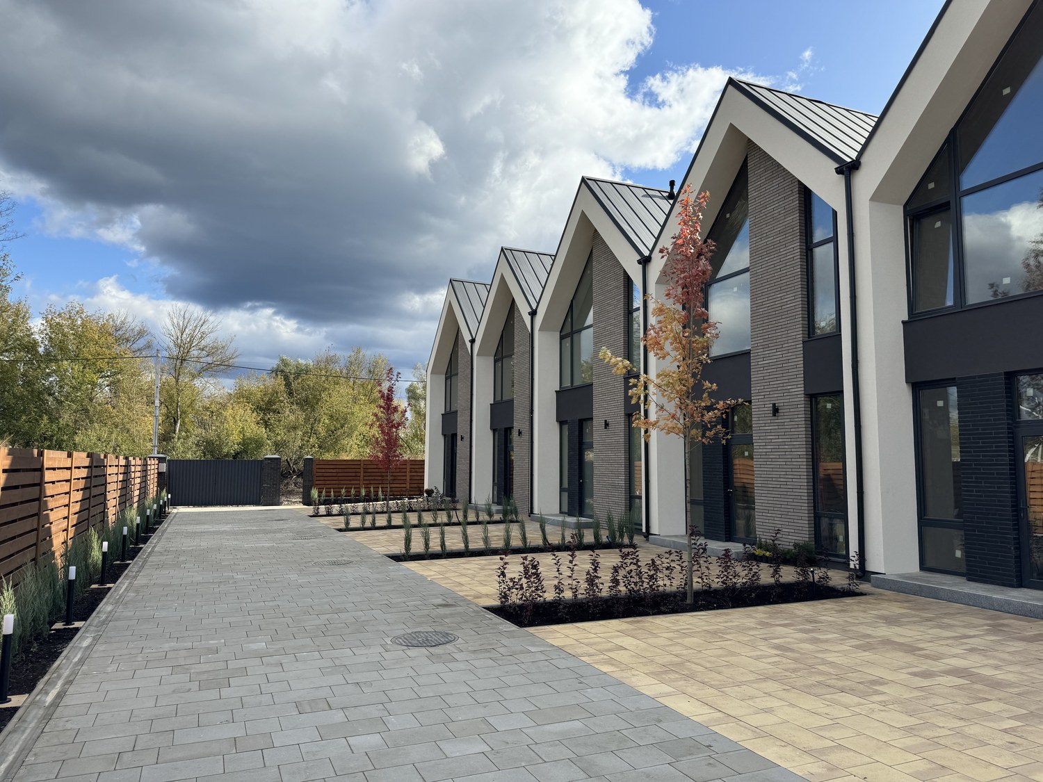 Completed townhouses at dusk, paved walkway and landscaping finished.