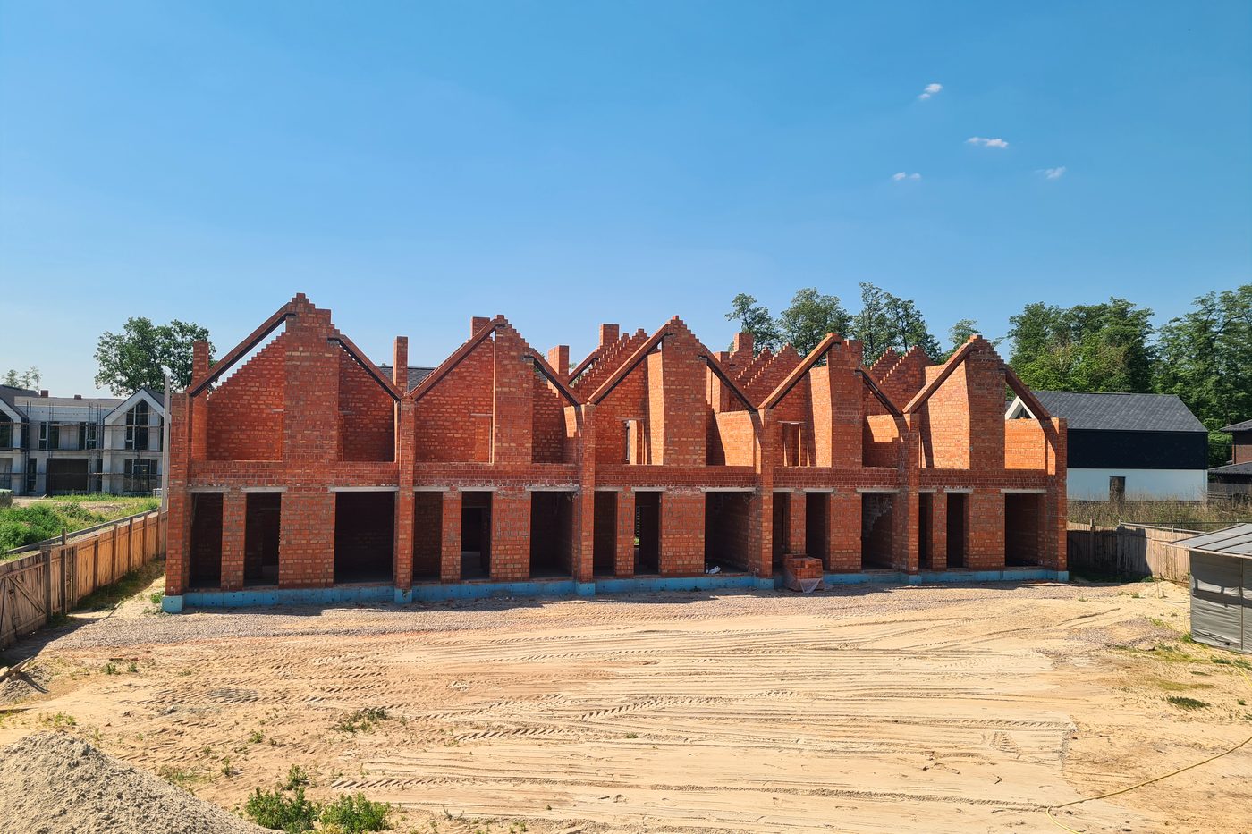 The whole terrace at shell stage: brick gables in a row against open ground.