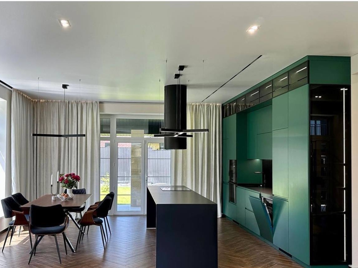 Completed kitchen with full cabinetry run, integrated appliances, and pendant lighting over an island.