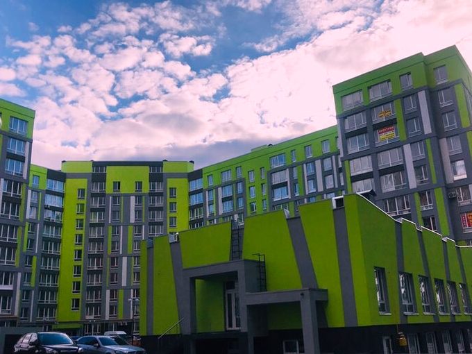 The finished complex: grey and lime-green facades on the connected buildings.