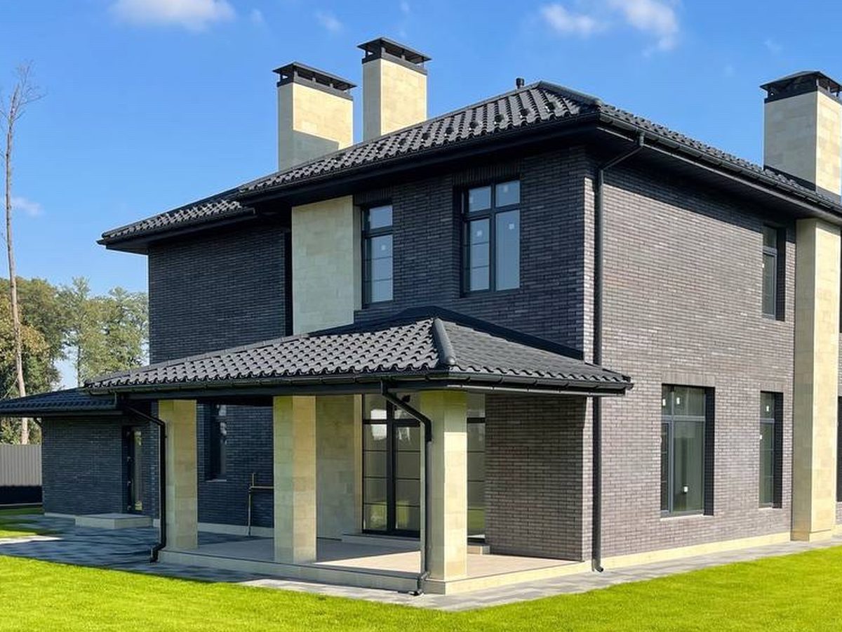 Completed custom home exterior, dark brick and stone facade.
