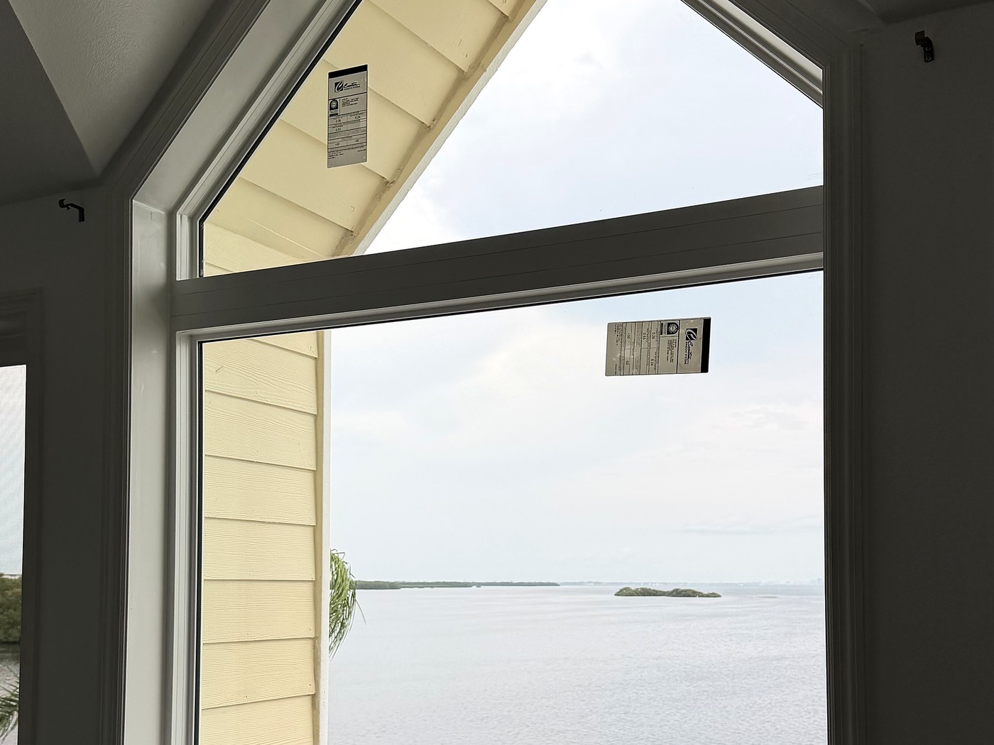 Peaked impact window framing an open water view dotted with small islands.
